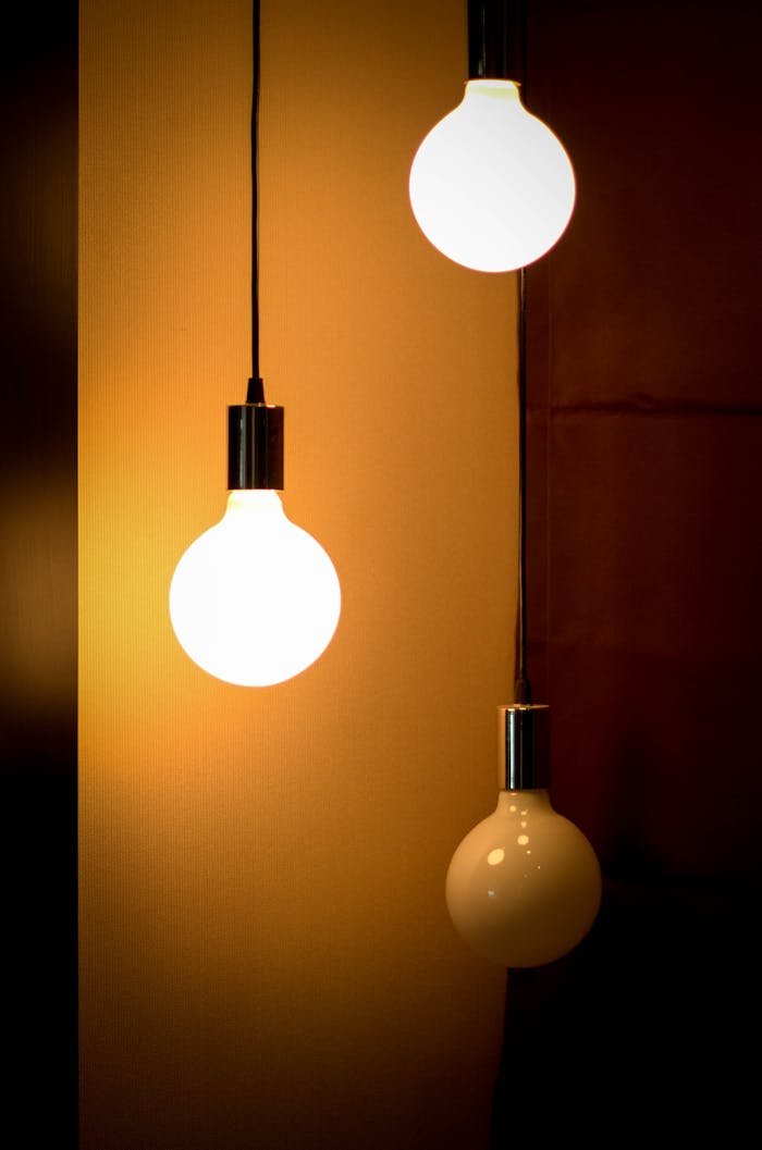 who-we-are Composition of three glowing light bulbs creating a warm ambiance. Ideal for energy and design themes.